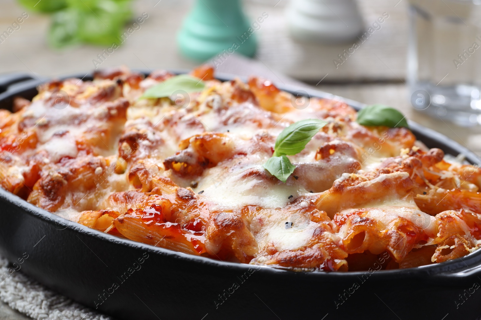 Photo of Delicious al forno pasta in baking dish on table, closeup