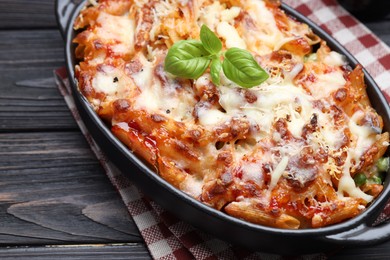 Photo of Delicious al forno pasta in baking dish on wooden table, closeup