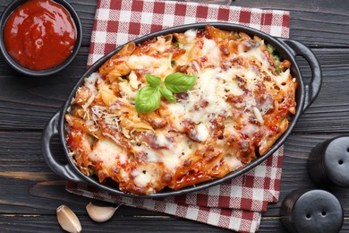 Photo of Delicious al forno pasta in baking dish on wooden table, flat lay