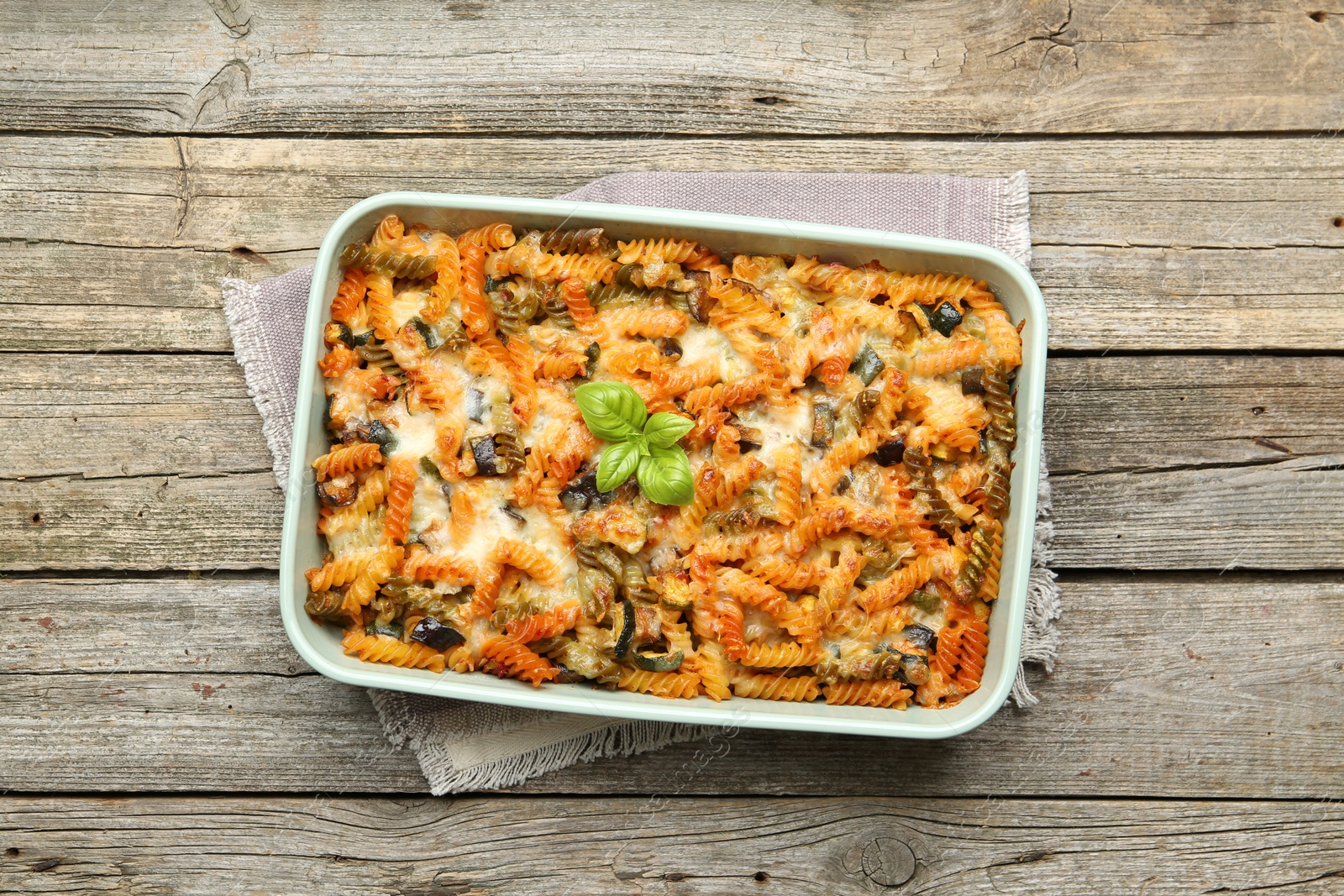 Photo of Delicious al forno pasta in baking dish on wooden table, top view