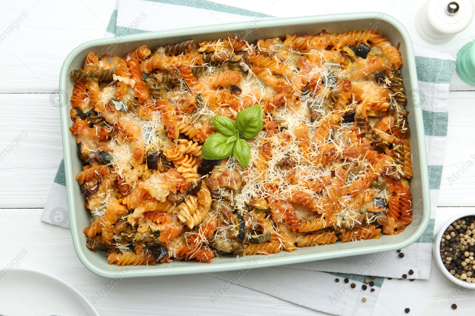 Photo of Delicious al forno pasta in baking dish on white wooden table, flat lay