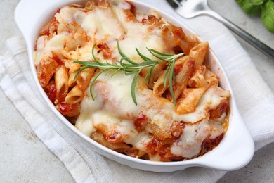 Photo of Delicious al forno pasta in baking dish on light table, closeup