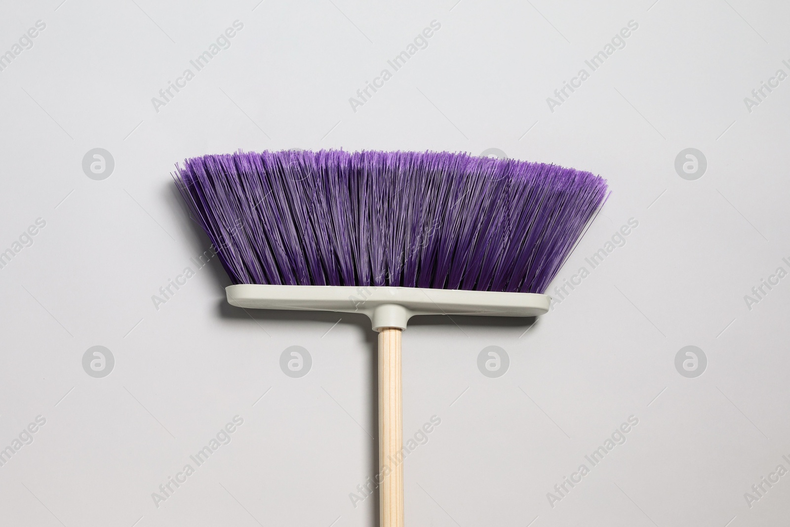 Photo of One broom on light grey background, top view. Cleaning tool