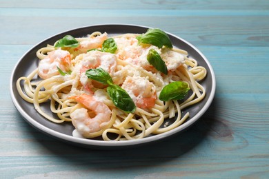 Photo of Tasty pasta with shrimps on light blue wooden table, closeup