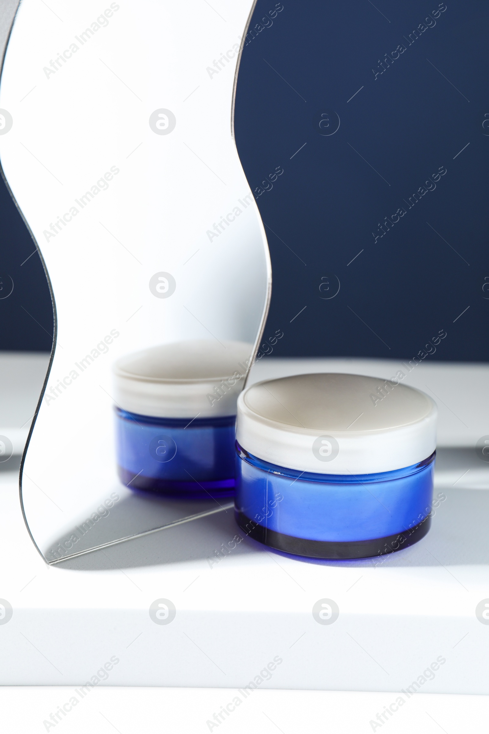 Photo of Stylish presentation of face cream against blue background