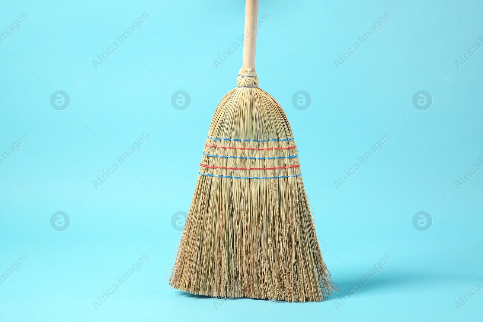 Photo of One corn straw broom on light blue background