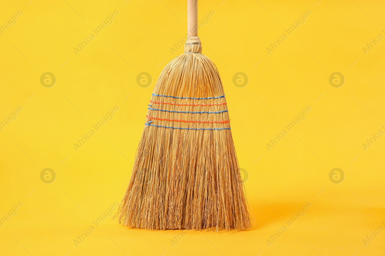 Photo of One corn straw broom on yellow background