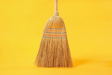 Photo of One corn straw broom on yellow background