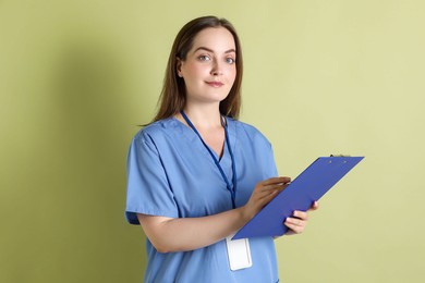 Professional nurse with clipboard on pale green background