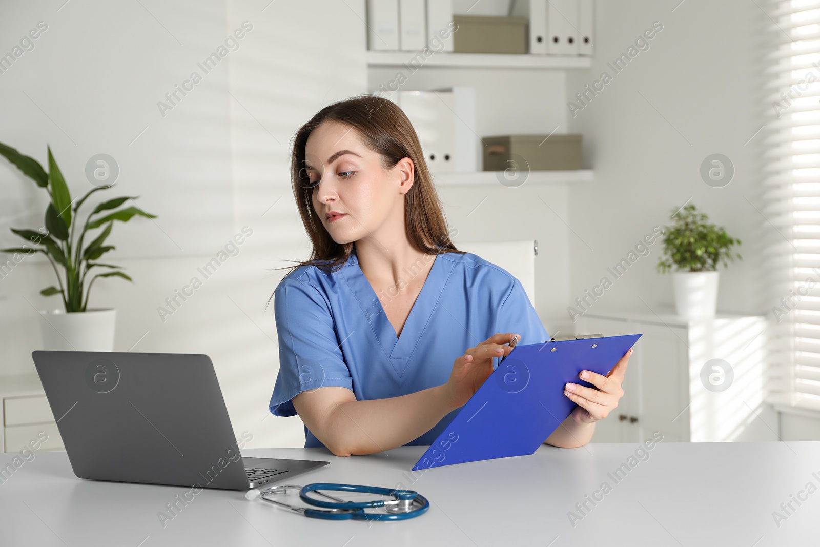 Photo of Young nurse working at desk in hospital