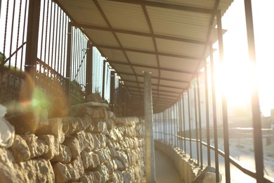 Photo of Pathway, fence and stone wall on city street in morning