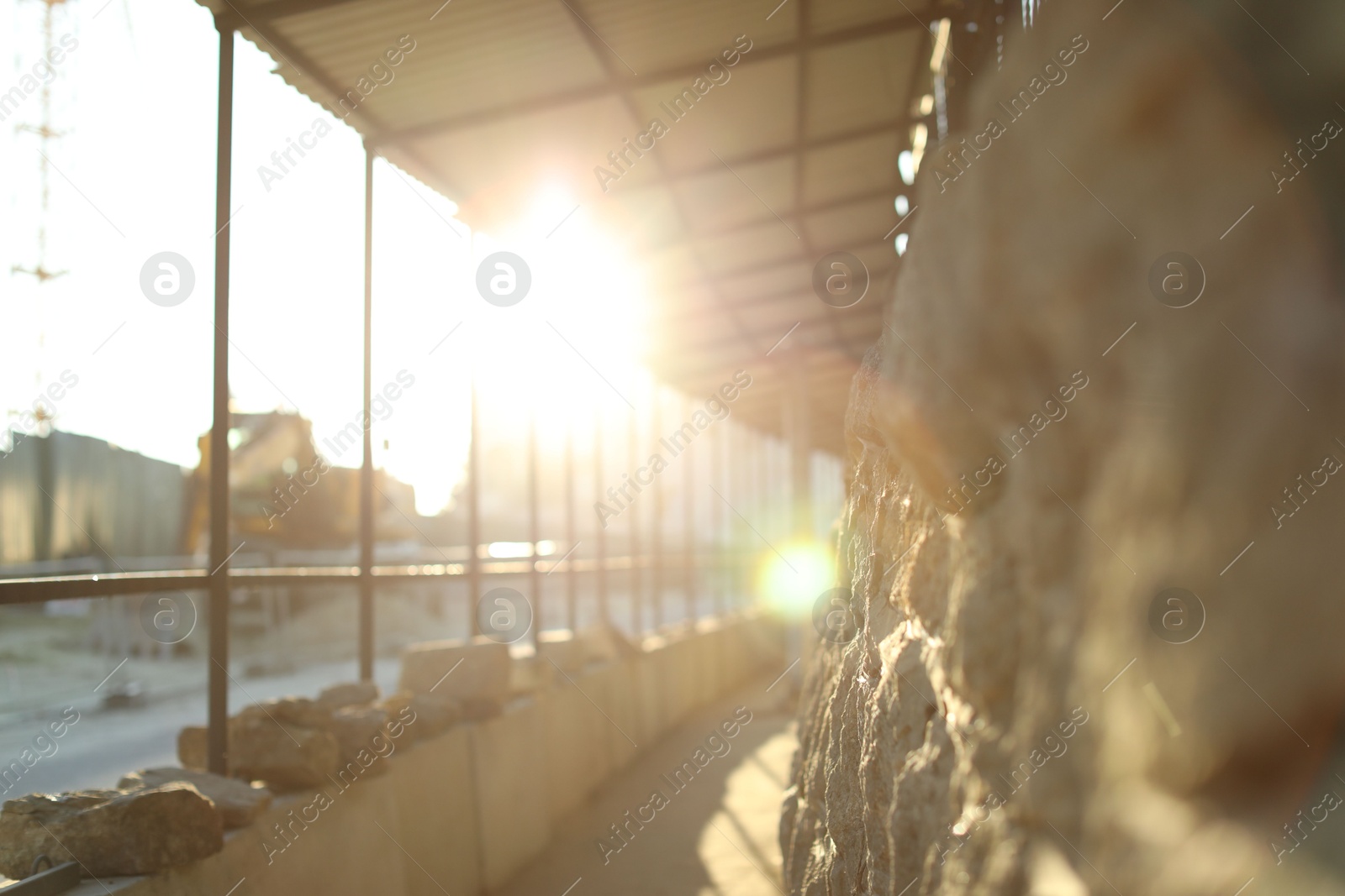 Photo of Pathway, fence and stone wall on city street in morning