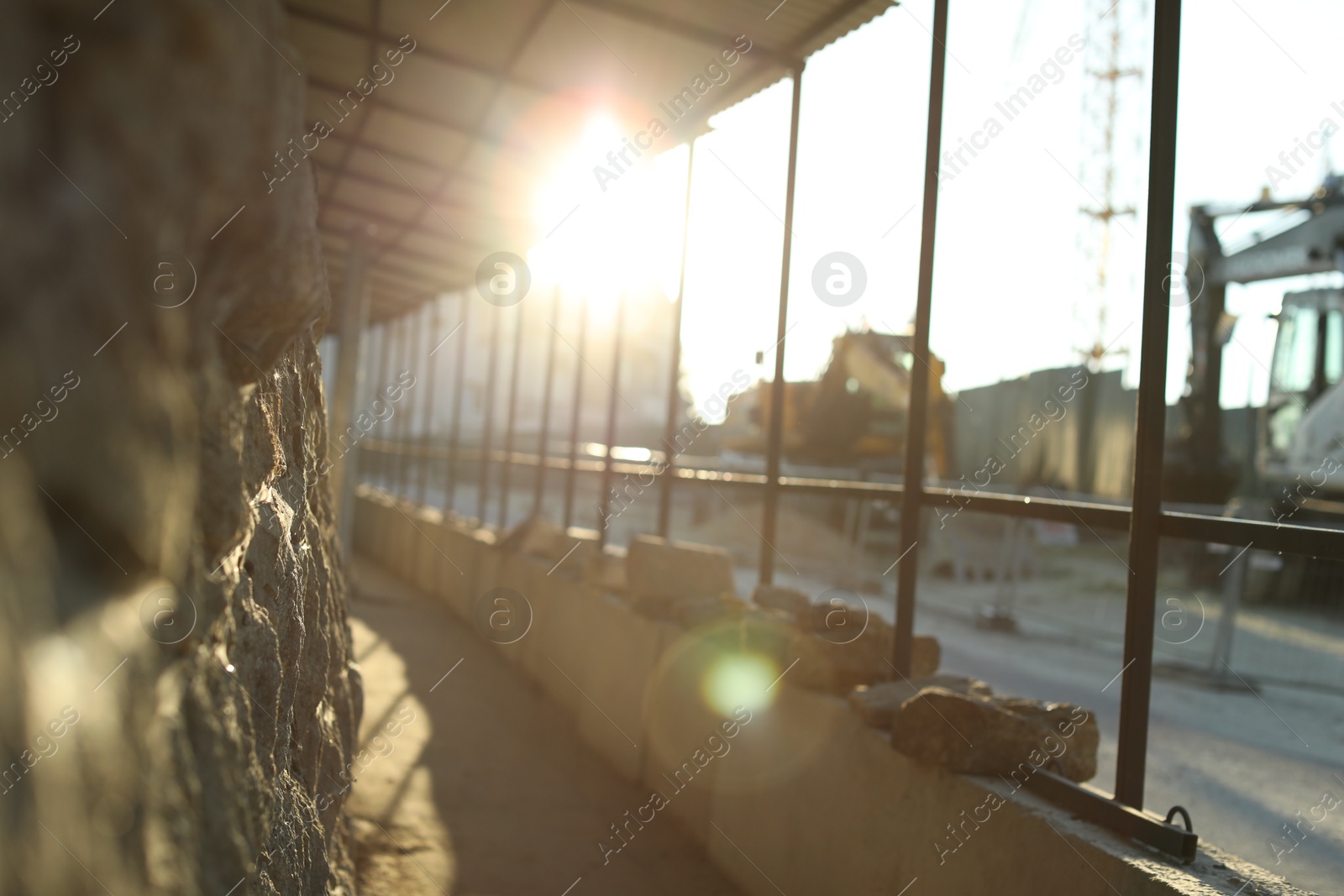 Photo of Pathway, fence and stone wall on city street in morning