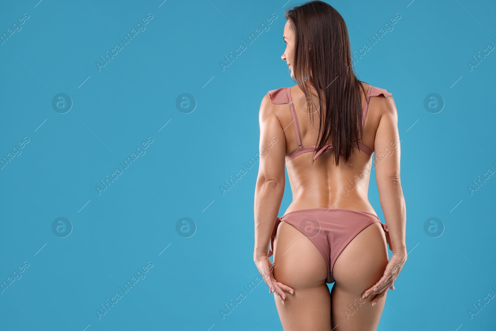 Photo of Woman in bikini on light blue background, space for text