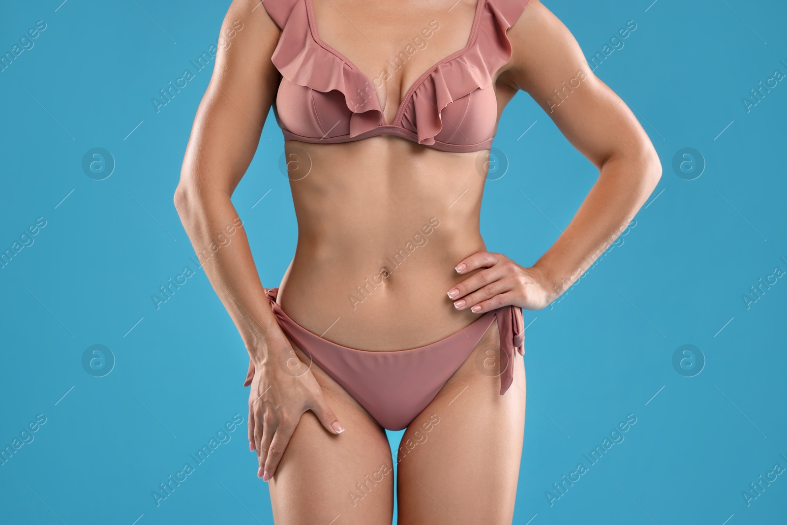 Photo of Woman in bikini on light blue background, closeup