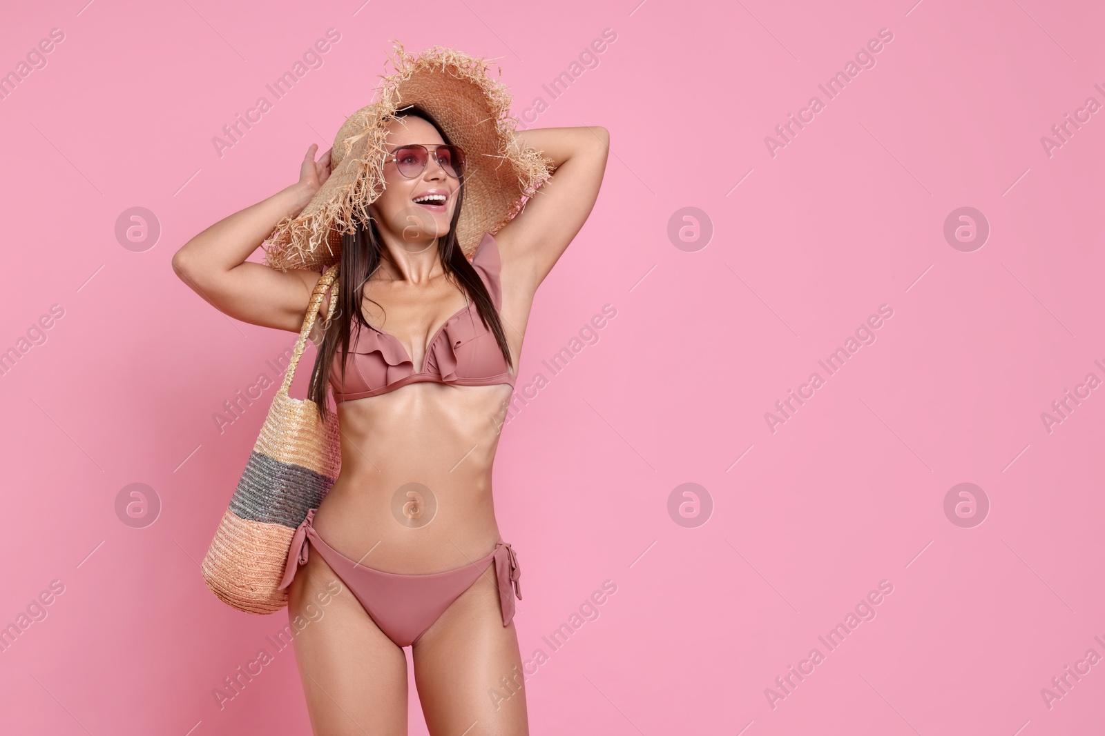 Photo of Woman in stylish bikini on pink background, space for text