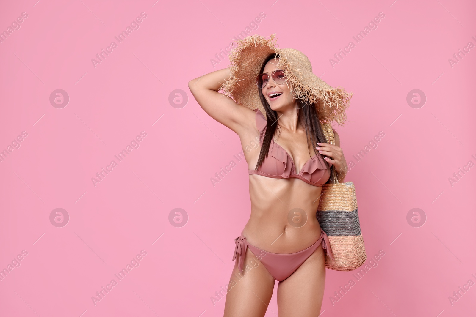 Photo of Woman in stylish bikini on pink background, space for text