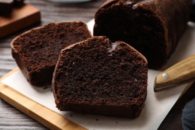 Photo of Delicious cut chocolate sponge cake on wooden table, closeup