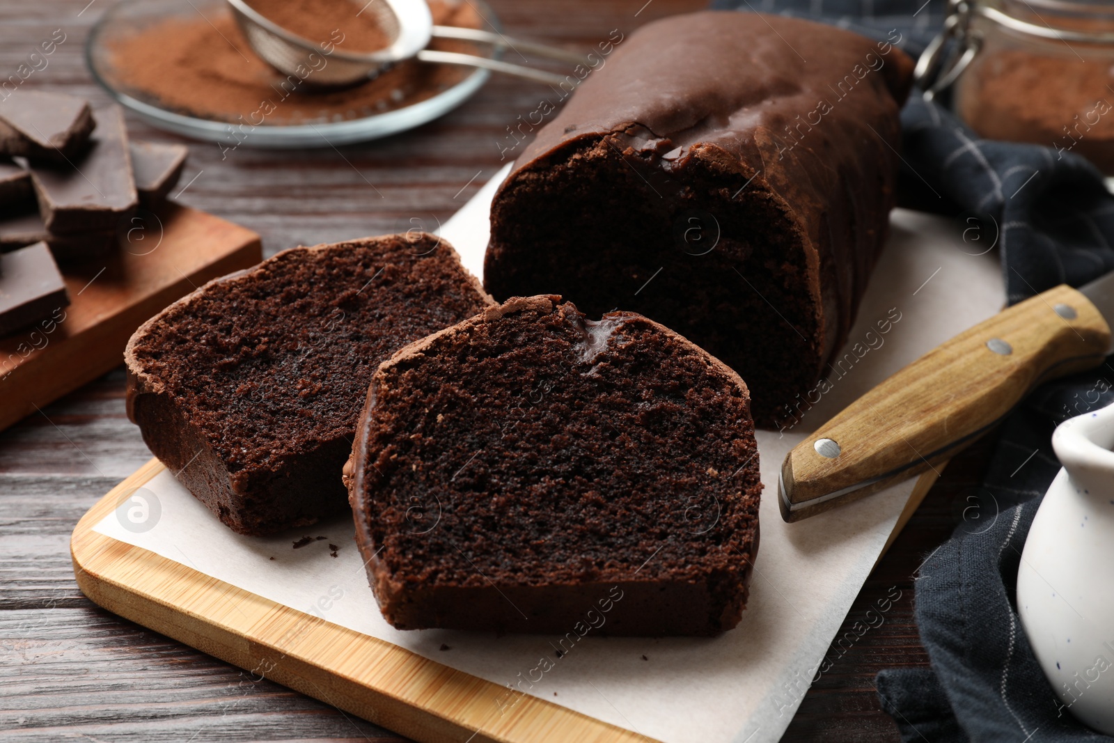 Photo of Delicious cut chocolate sponge cake on wooden table, closeup