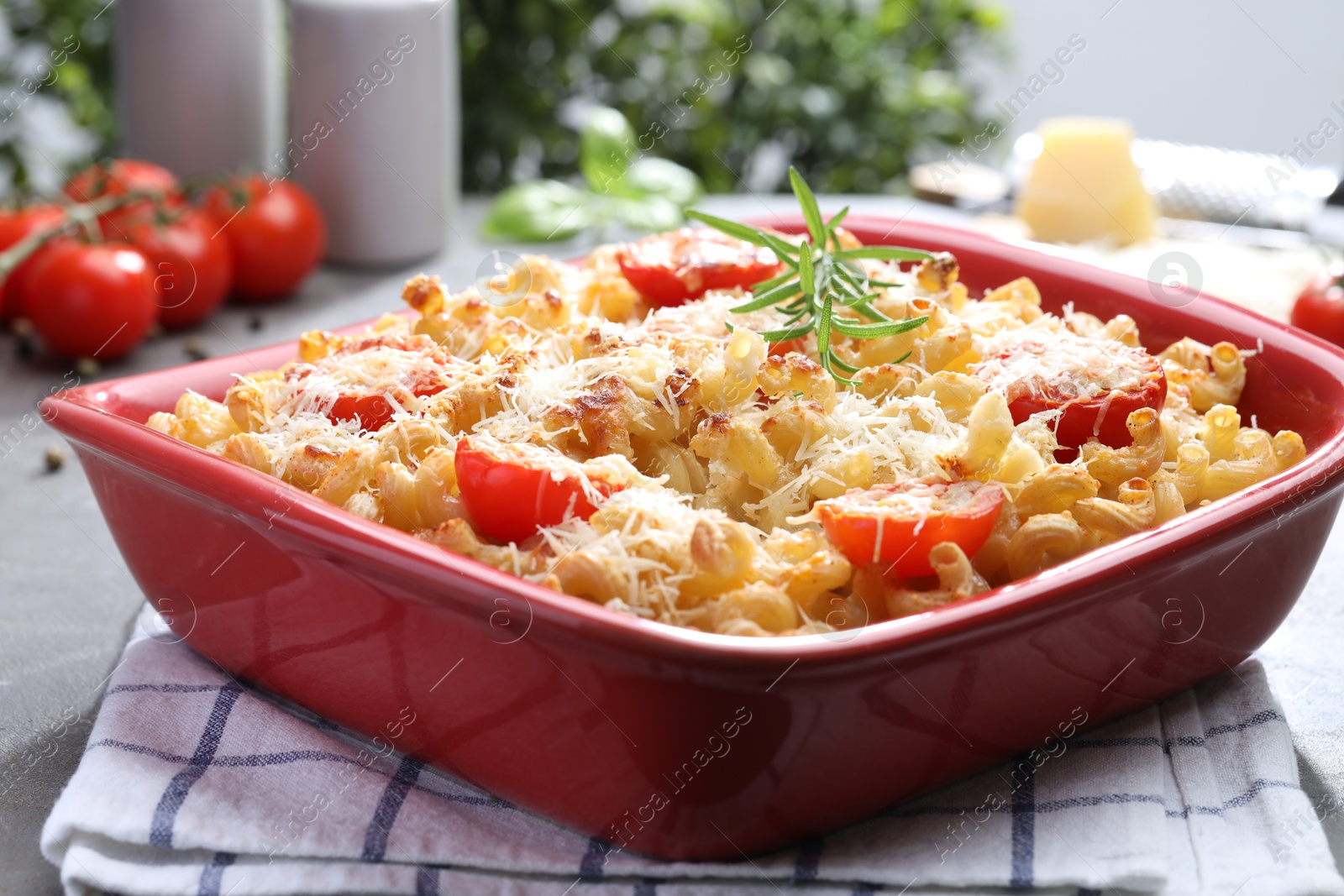 Photo of Delicious al forno pasta in baking dish on grey table, closeup