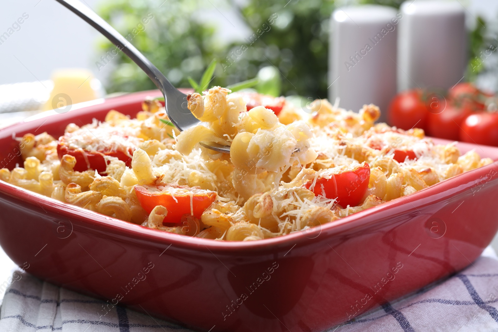 Photo of Eating delicious al forno pasta at grey table, closeup