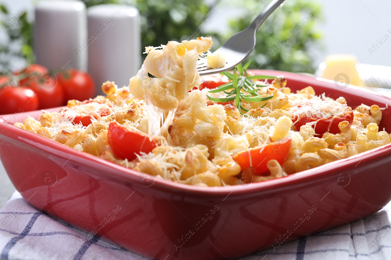 Photo of Eating delicious al forno pasta at grey table, closeup