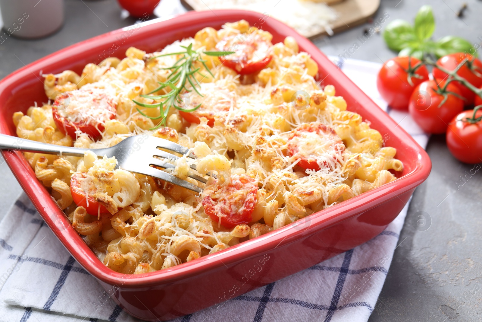 Photo of Delicious al forno pasta in baking dish on grey table