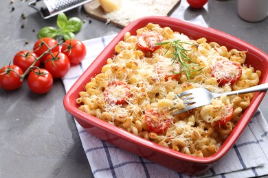 Photo of Delicious al forno pasta in baking dish on grey table