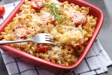 Photo of Delicious al forno pasta in baking dish on grey table