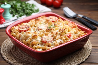 Photo of Delicious al forno pasta in baking dish on wooden table, closeup