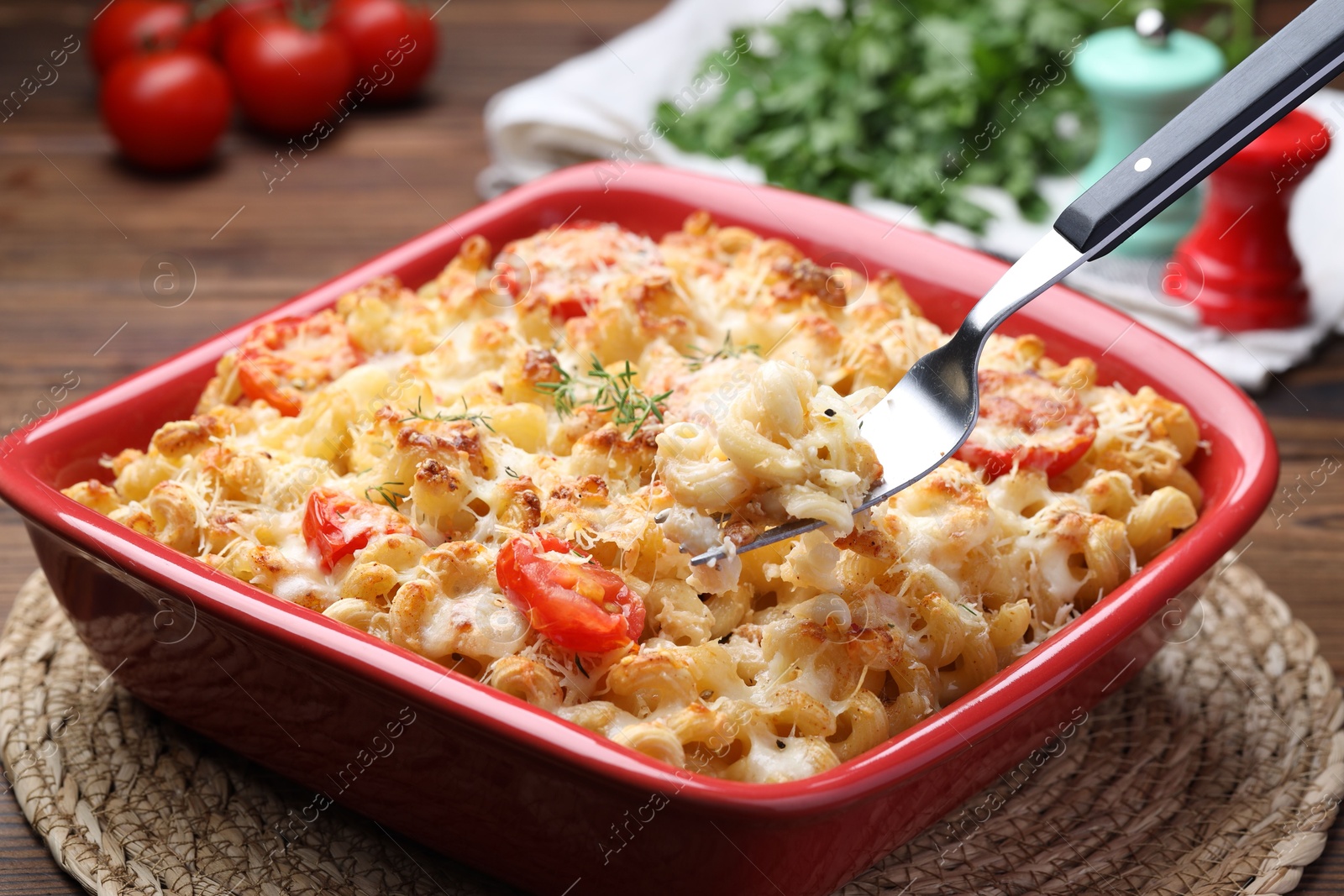 Photo of Eating delicious al forno pasta at wooden table, closeup