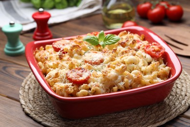 Photo of Delicious al forno pasta in baking dish on wooden table, closeup