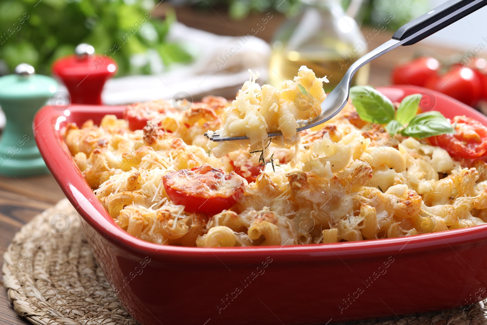 Photo of Eating delicious al forno pasta at wooden table, closeup