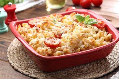 Photo of Delicious al forno pasta in baking dish on wooden table, closeup