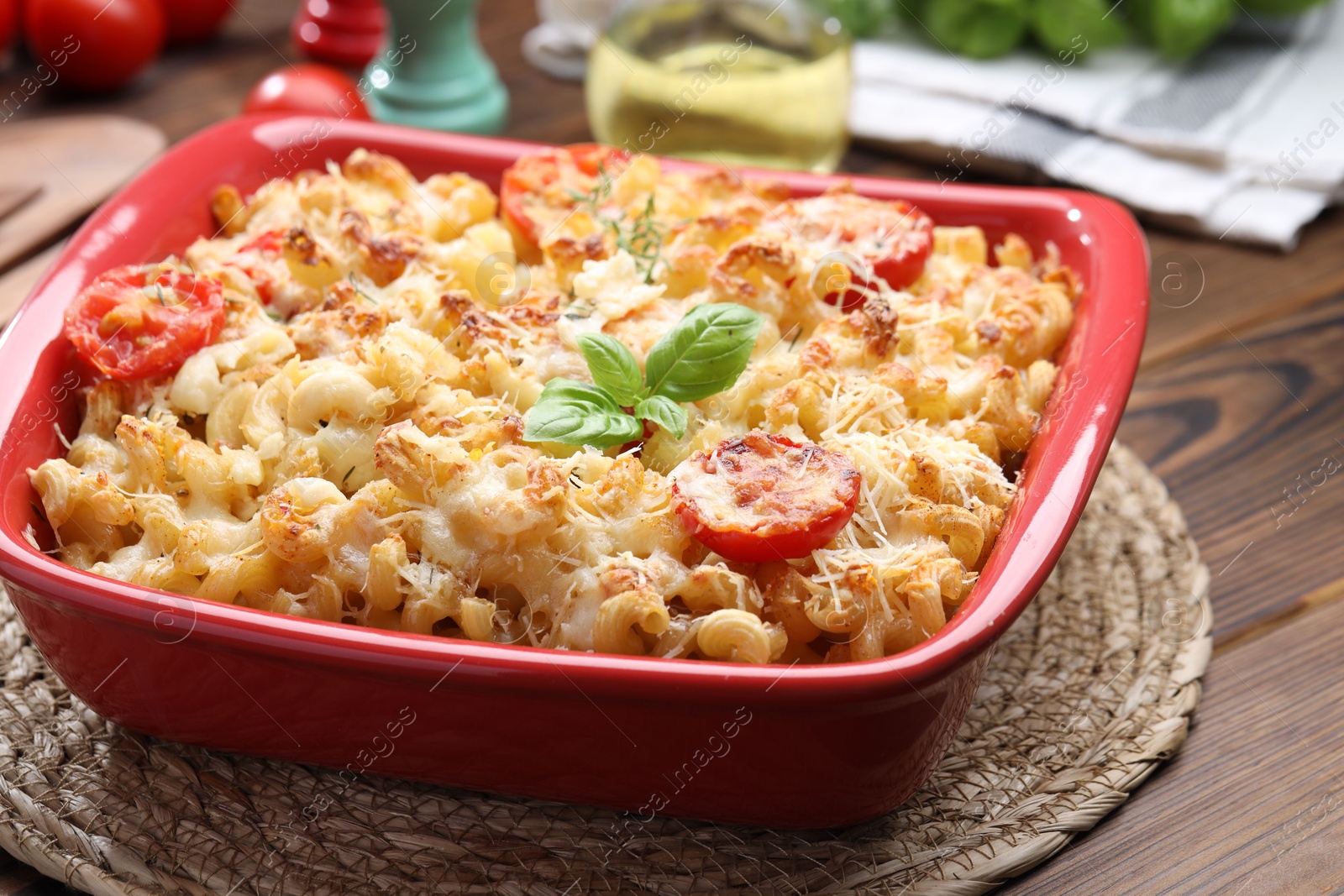 Photo of Delicious al forno pasta in baking dish on wooden table, closeup