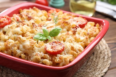 Photo of Delicious al forno pasta in baking dish on wooden table, closeup