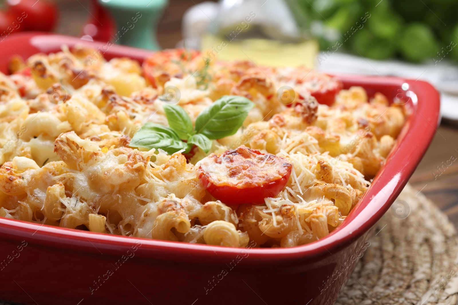 Photo of Delicious al forno pasta in baking dish on wooden table, closeup