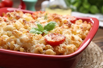 Photo of Delicious al forno pasta in baking dish on wooden table, closeup