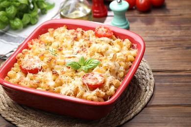 Photo of Delicious al forno pasta in baking dish on wooden table, closeup