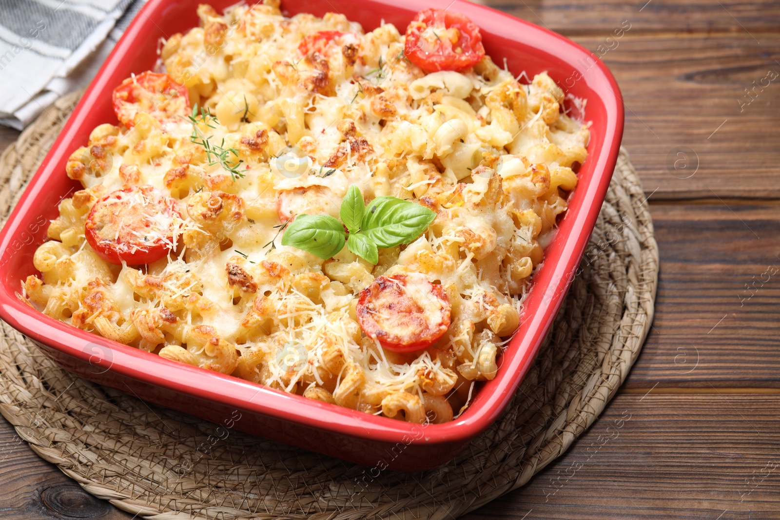 Photo of Delicious al forno pasta in baking dish on wooden table, closeup