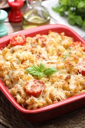 Photo of Delicious al forno pasta in baking dish on wooden table, closeup