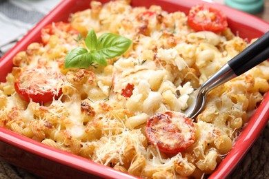 Photo of Eating delicious al forno pasta at table, closeup