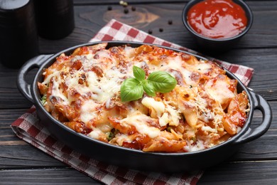 Photo of Delicious al forno pasta in baking dish on wooden table, closeup