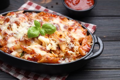 Photo of Delicious al forno pasta in baking dish on wooden table, closeup