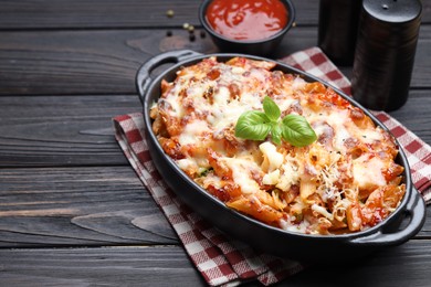 Photo of Delicious al forno pasta in baking dish on wooden table