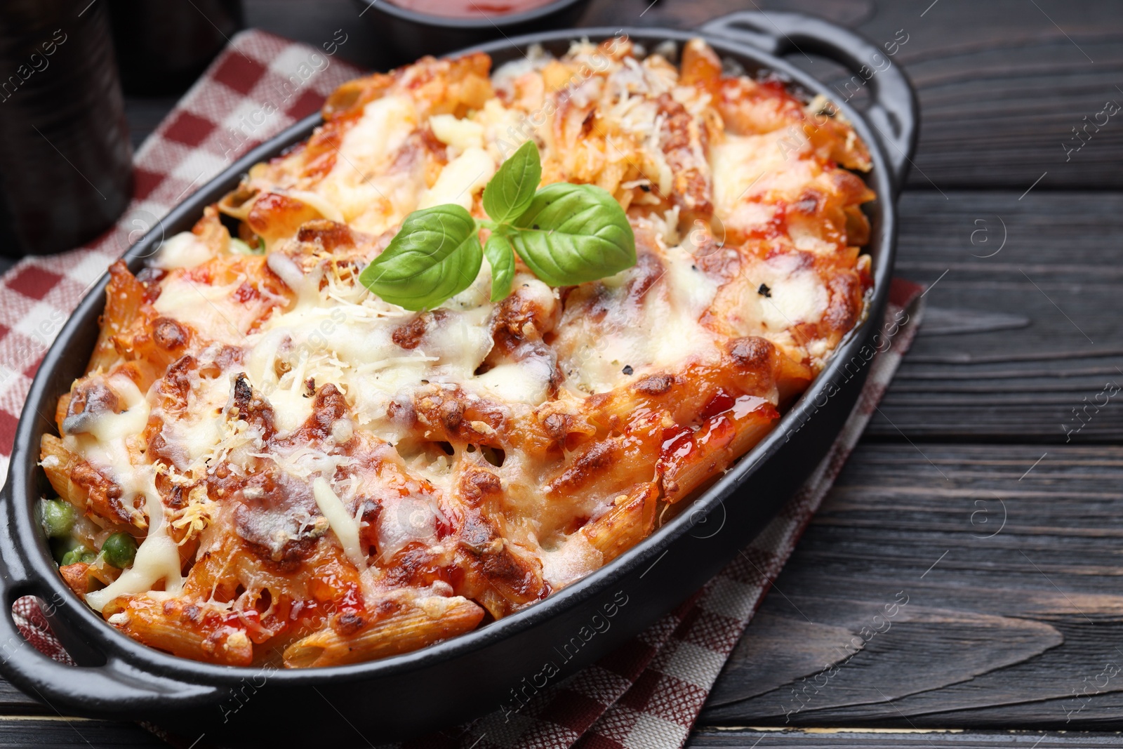 Photo of Delicious al forno pasta in baking dish on wooden table, closeup