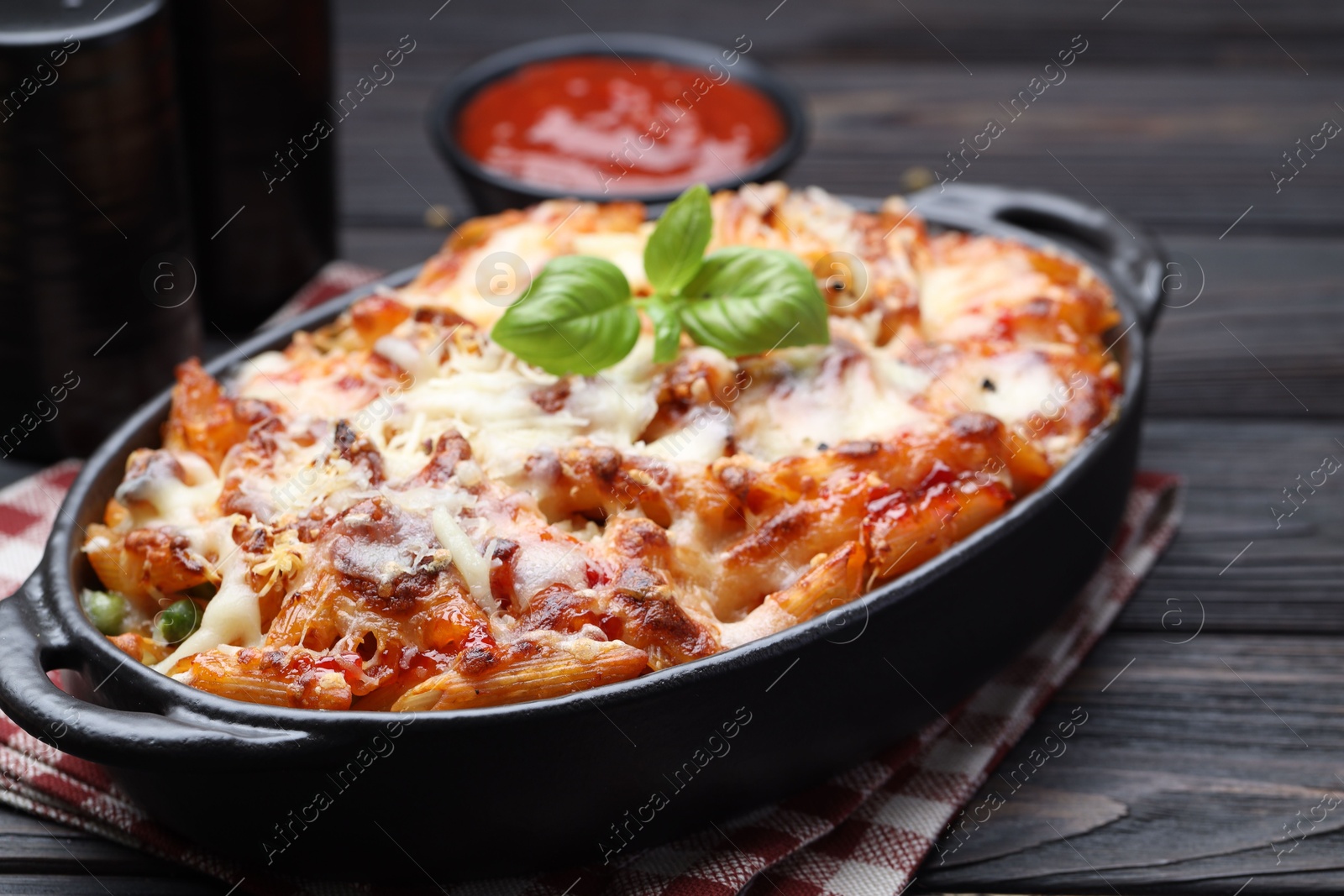 Photo of Delicious al forno pasta in baking dish on wooden table, closeup