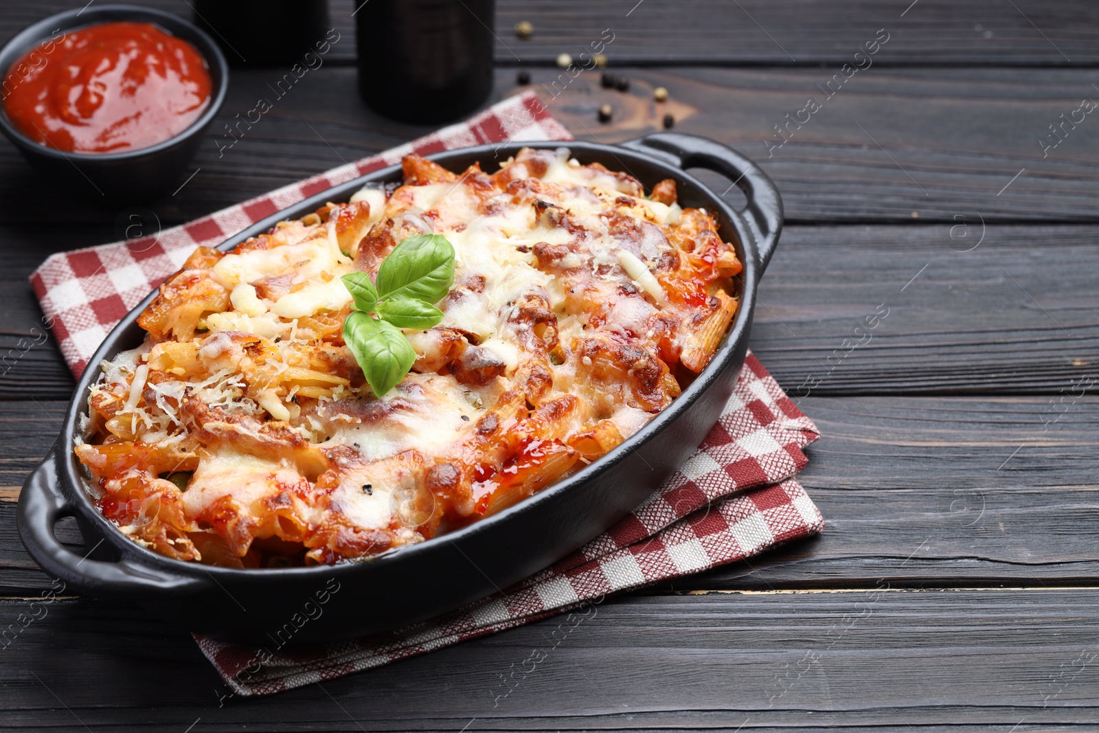 Photo of Delicious al forno pasta in baking dish on wooden table