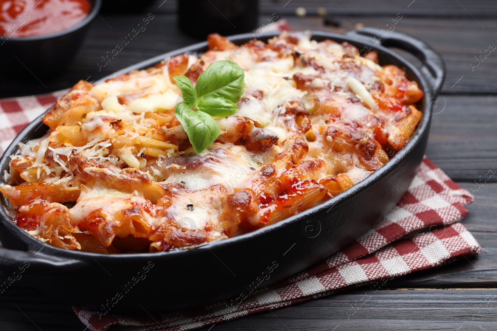 Photo of Delicious al forno pasta in baking dish on wooden table, closeup