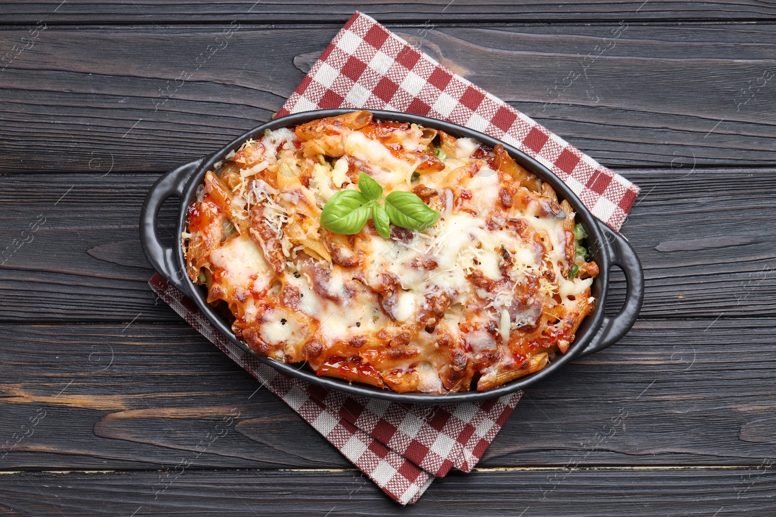 Photo of Delicious al forno pasta in baking dish on wooden table, top view